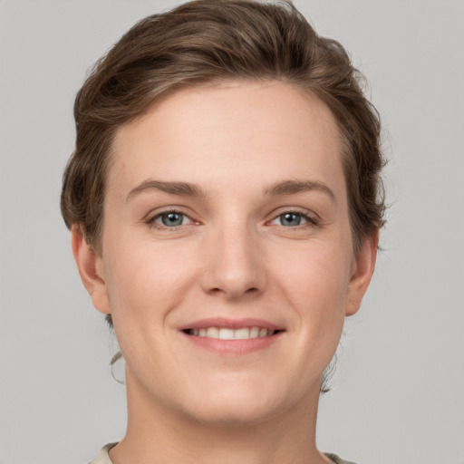 Joyful white young-adult female with short  brown hair and grey eyes