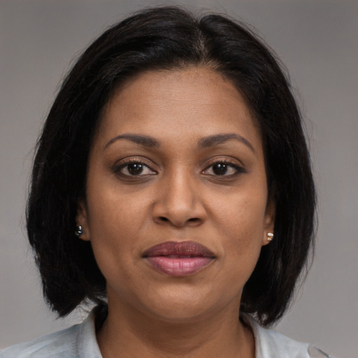 Joyful black adult female with medium  brown hair and brown eyes
