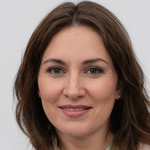 Joyful white adult female with long  brown hair and brown eyes