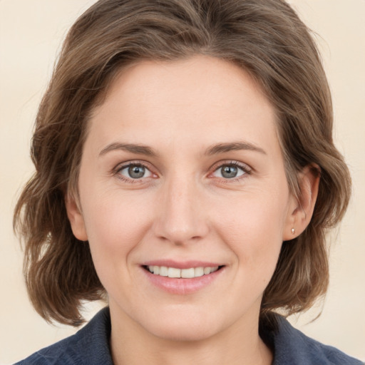 Joyful white young-adult female with medium  brown hair and grey eyes