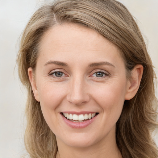 Joyful white young-adult female with long  brown hair and blue eyes