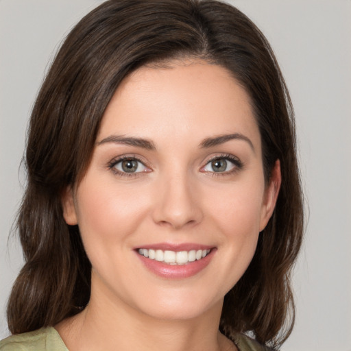 Joyful white young-adult female with medium  brown hair and green eyes