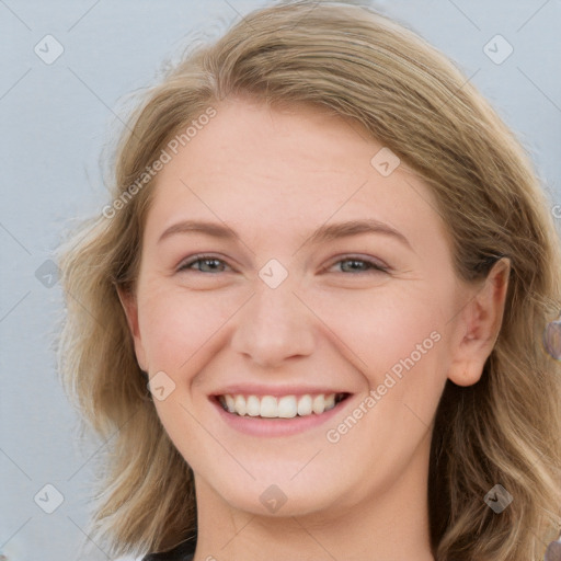 Joyful white young-adult female with long  brown hair and blue eyes