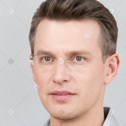 Joyful white young-adult male with short  brown hair and grey eyes