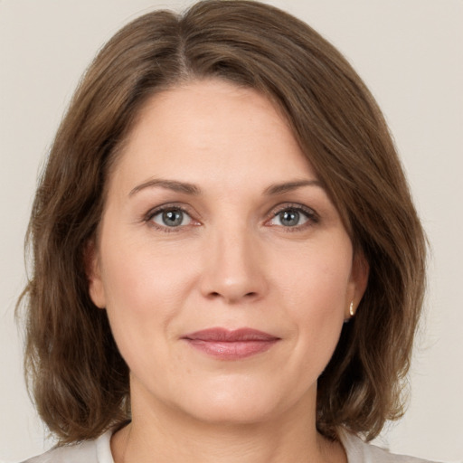 Joyful white adult female with medium  brown hair and grey eyes