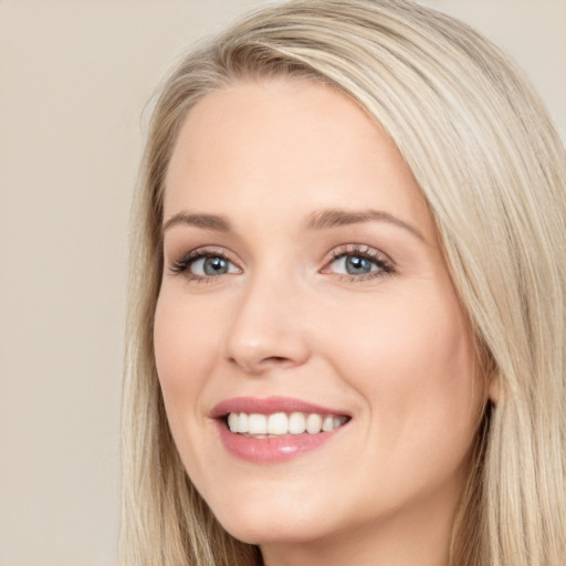 Joyful white young-adult female with long  brown hair and blue eyes