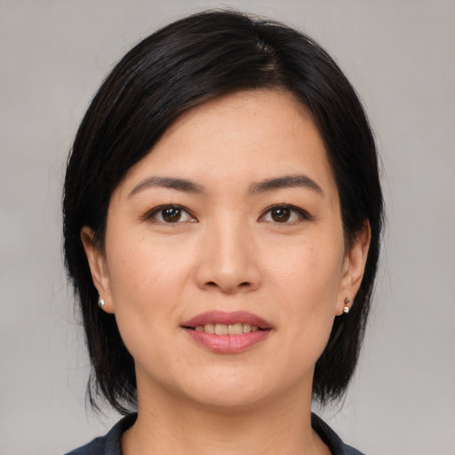 Joyful asian young-adult female with medium  black hair and brown eyes
