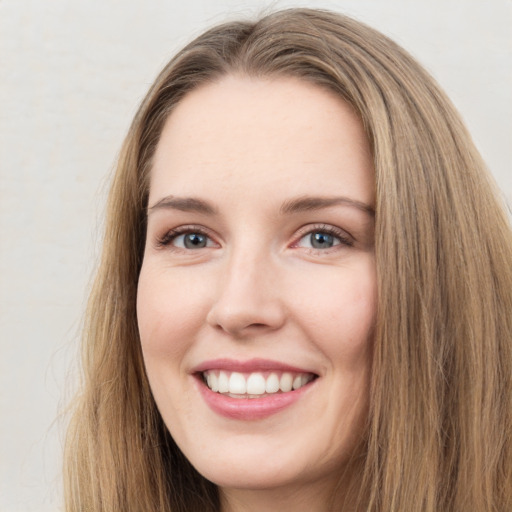 Joyful white young-adult female with long  brown hair and green eyes