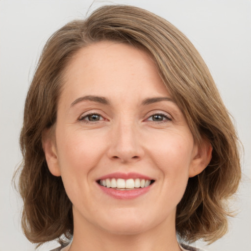 Joyful white young-adult female with medium  brown hair and green eyes