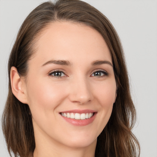 Joyful white young-adult female with long  brown hair and grey eyes