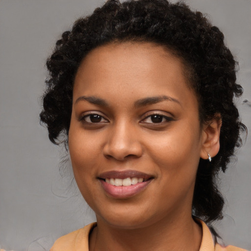 Joyful black young-adult female with long  brown hair and brown eyes