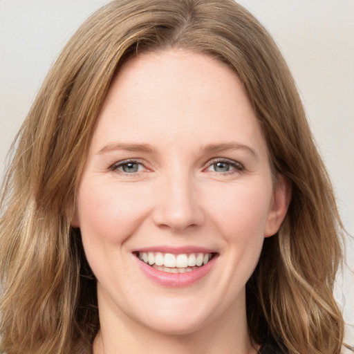 Joyful white young-adult female with long  brown hair and green eyes