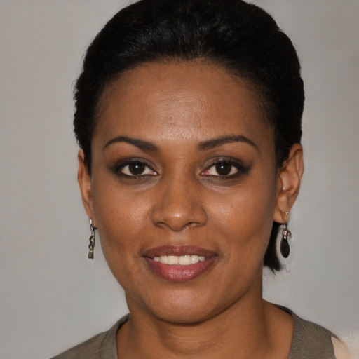 Joyful black young-adult female with short  black hair and brown eyes