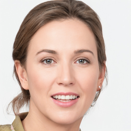 Joyful white young-adult female with medium  brown hair and grey eyes