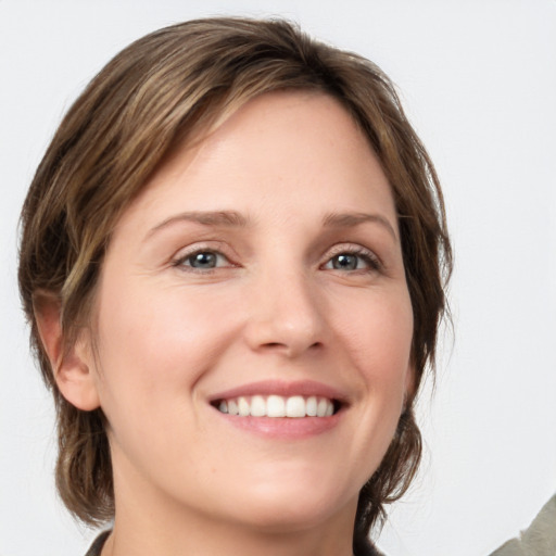 Joyful white young-adult female with medium  brown hair and grey eyes