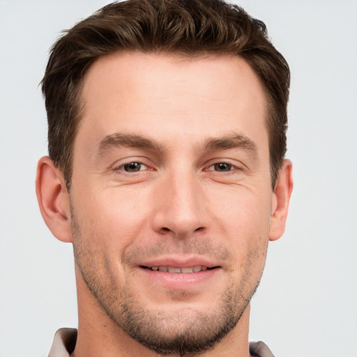 Joyful white young-adult male with short  brown hair and grey eyes