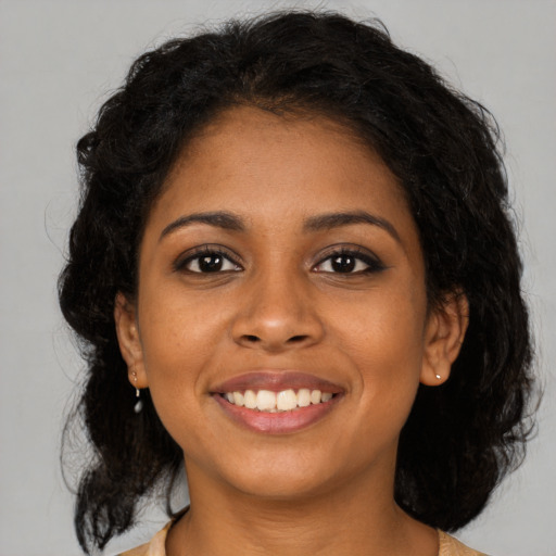 Joyful black young-adult female with medium  brown hair and brown eyes