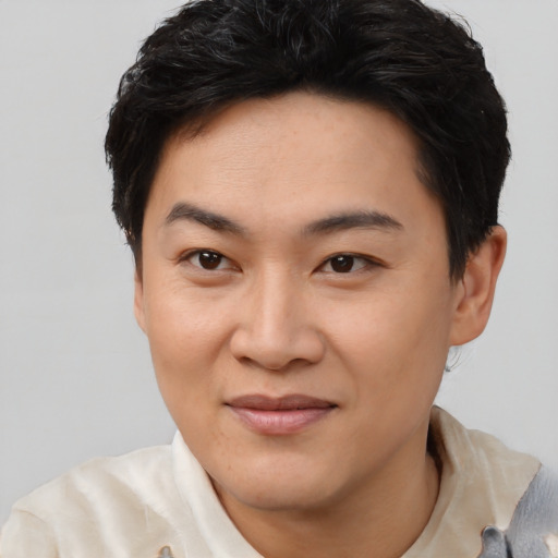 Joyful asian young-adult male with short  brown hair and brown eyes