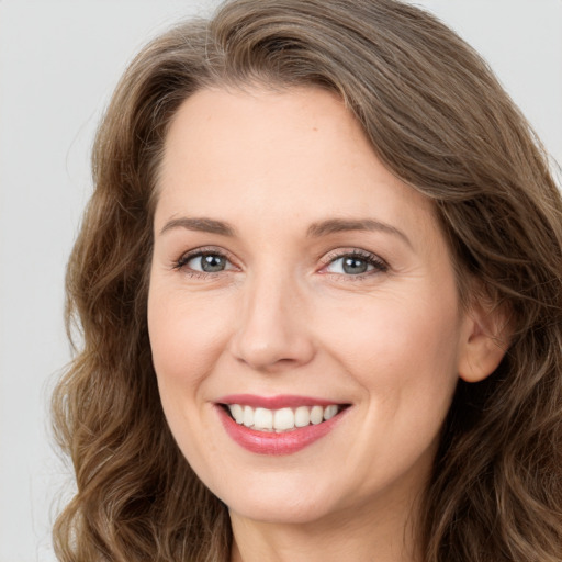 Joyful white young-adult female with long  brown hair and green eyes