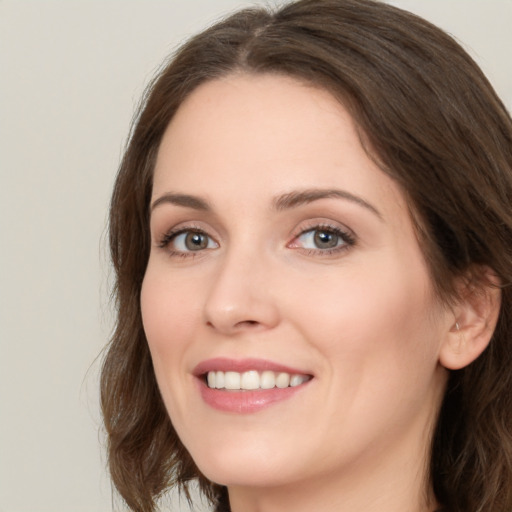 Joyful white young-adult female with long  brown hair and green eyes