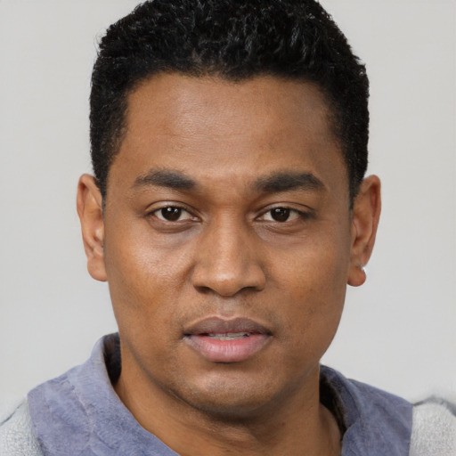 Joyful black young-adult male with short  black hair and brown eyes