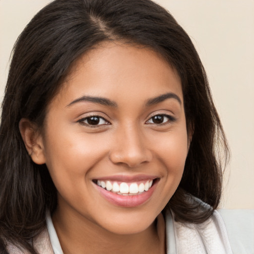 Joyful latino young-adult female with long  brown hair and brown eyes