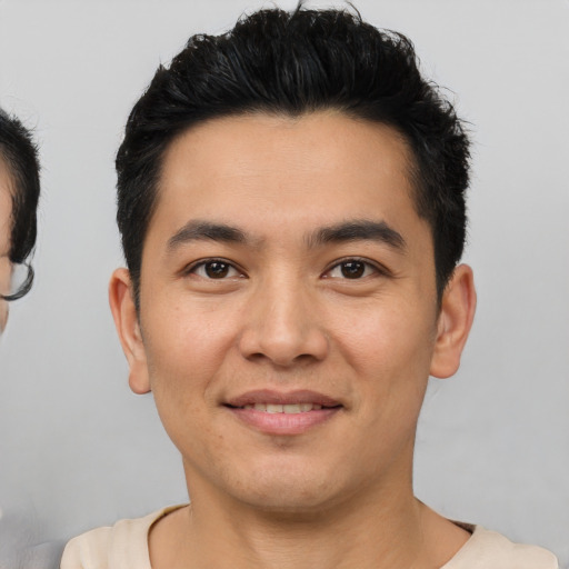 Joyful latino young-adult male with short  brown hair and brown eyes