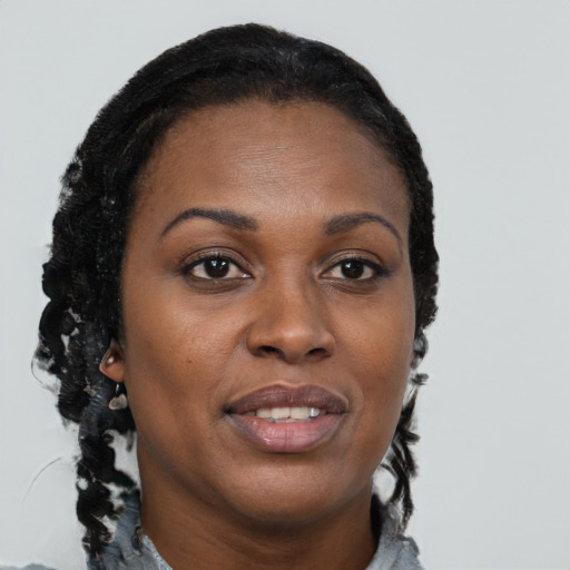 Joyful black young-adult female with long  brown hair and brown eyes