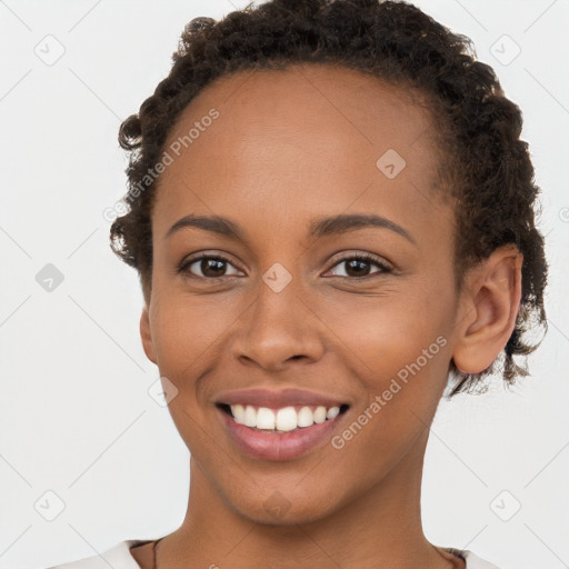 Joyful black young-adult female with short  brown hair and brown eyes