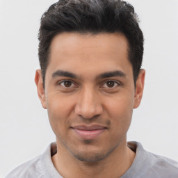 Joyful white young-adult male with short  black hair and brown eyes