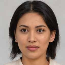 Joyful latino young-adult female with medium  brown hair and brown eyes