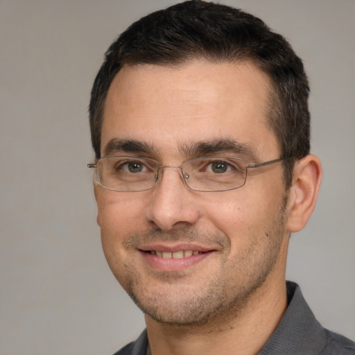 Joyful white adult male with short  black hair and brown eyes