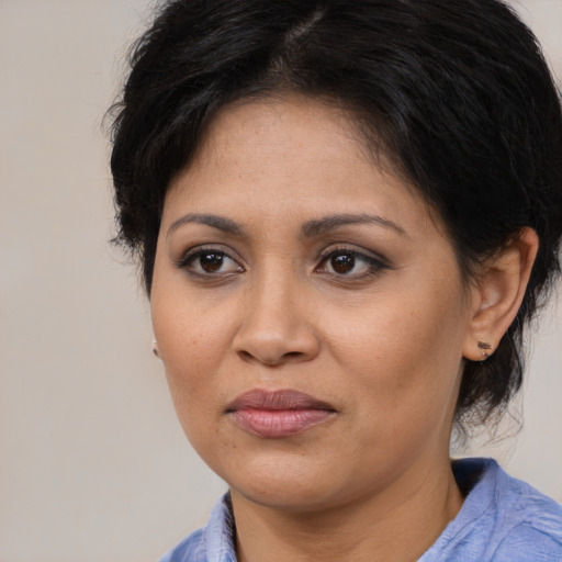 Joyful latino adult female with medium  brown hair and brown eyes