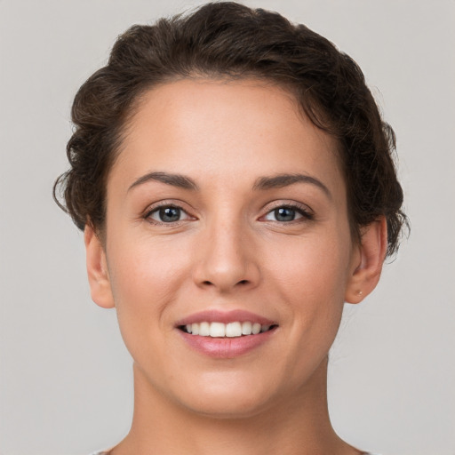 Joyful white young-adult female with short  brown hair and grey eyes