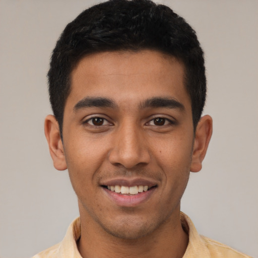 Joyful latino young-adult male with short  black hair and brown eyes
