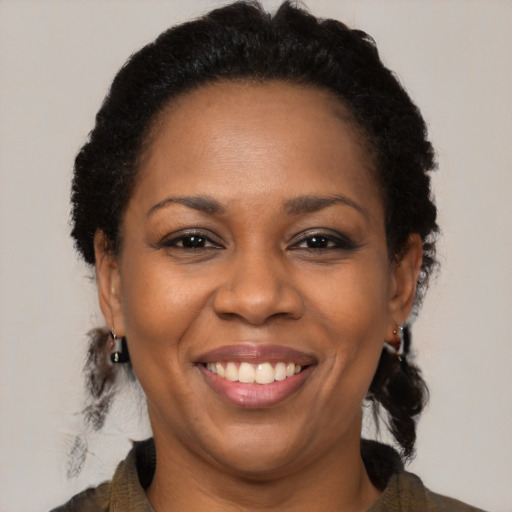 Joyful black adult female with medium  brown hair and brown eyes