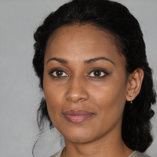 Joyful black young-adult female with medium  black hair and brown eyes