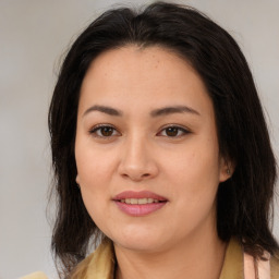 Joyful latino young-adult female with medium  brown hair and brown eyes