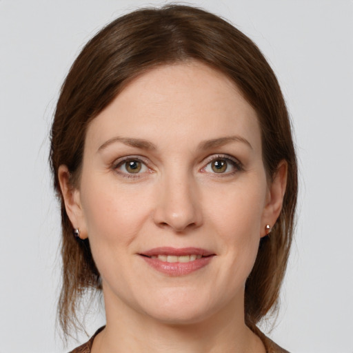 Joyful white young-adult female with medium  brown hair and grey eyes