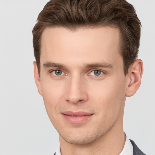 Joyful white young-adult male with short  brown hair and grey eyes