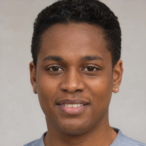 Joyful black young-adult male with short  black hair and brown eyes