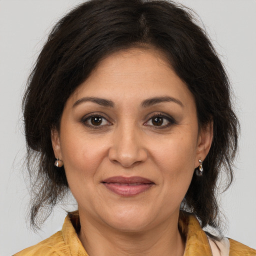 Joyful latino adult female with medium  brown hair and brown eyes