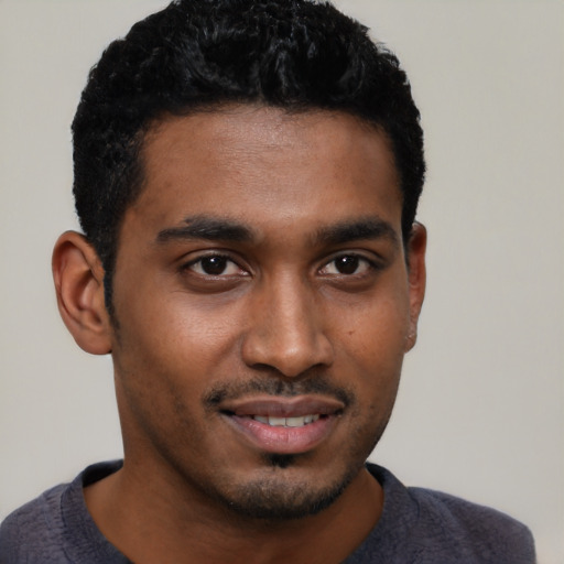 Joyful black young-adult male with short  brown hair and brown eyes