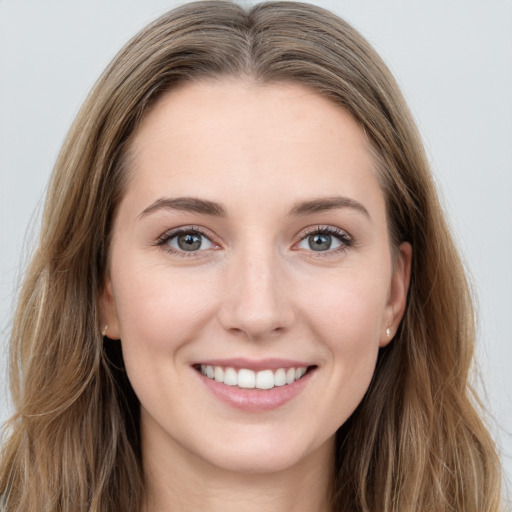 Joyful white young-adult female with long  brown hair and grey eyes