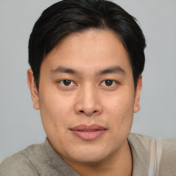 Joyful asian young-adult male with short  brown hair and brown eyes