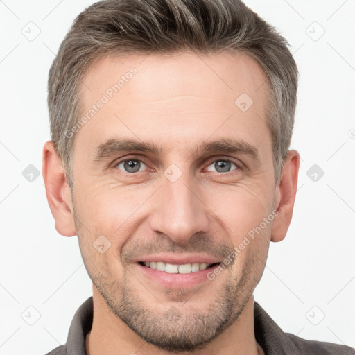 Joyful white young-adult male with short  brown hair and grey eyes