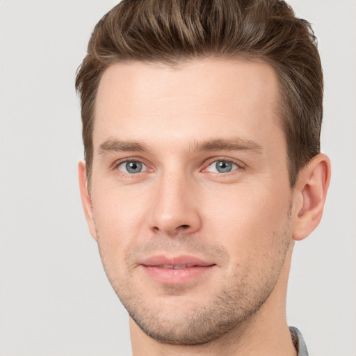 Joyful white young-adult male with short  brown hair and grey eyes