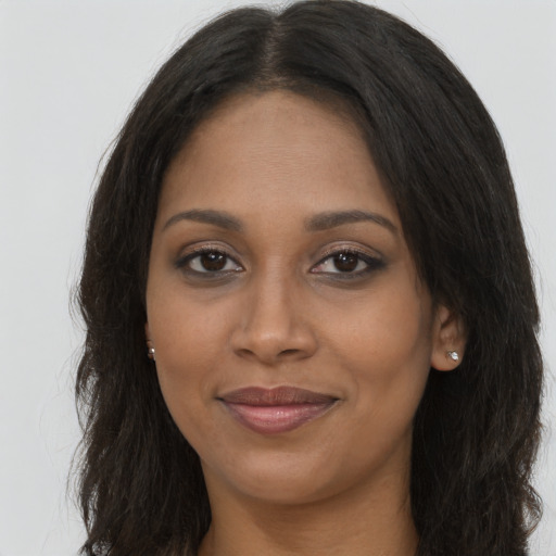 Joyful black young-adult female with long  brown hair and brown eyes