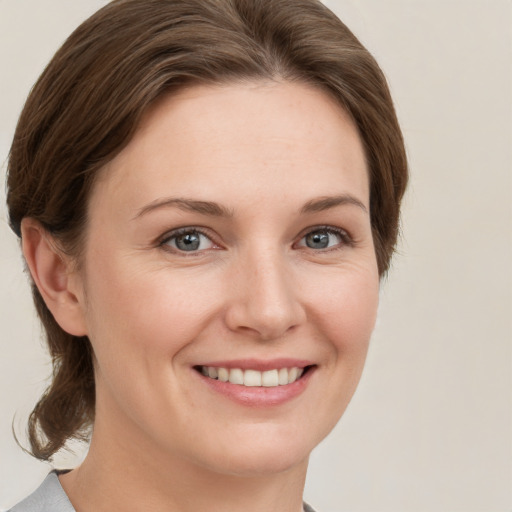 Joyful white young-adult female with medium  brown hair and grey eyes