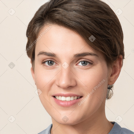 Joyful white young-adult female with short  brown hair and grey eyes